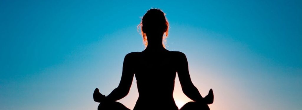 Persona meditando con energía Reiki fluyendo a través de los chakras